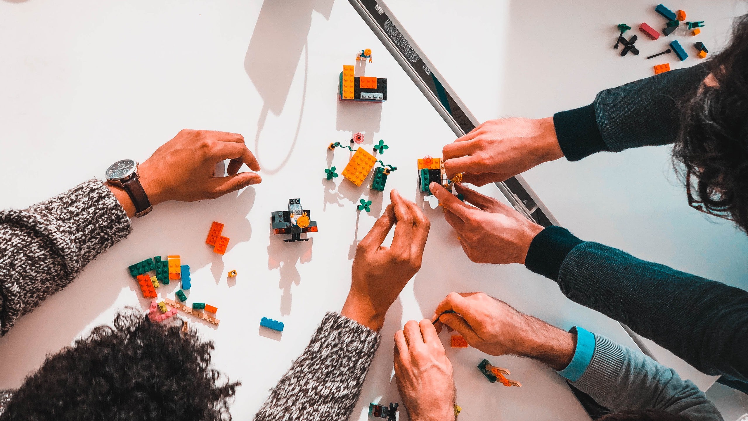 Overhead photo of a group of people assembling LEGO as part of a design thinking workshop