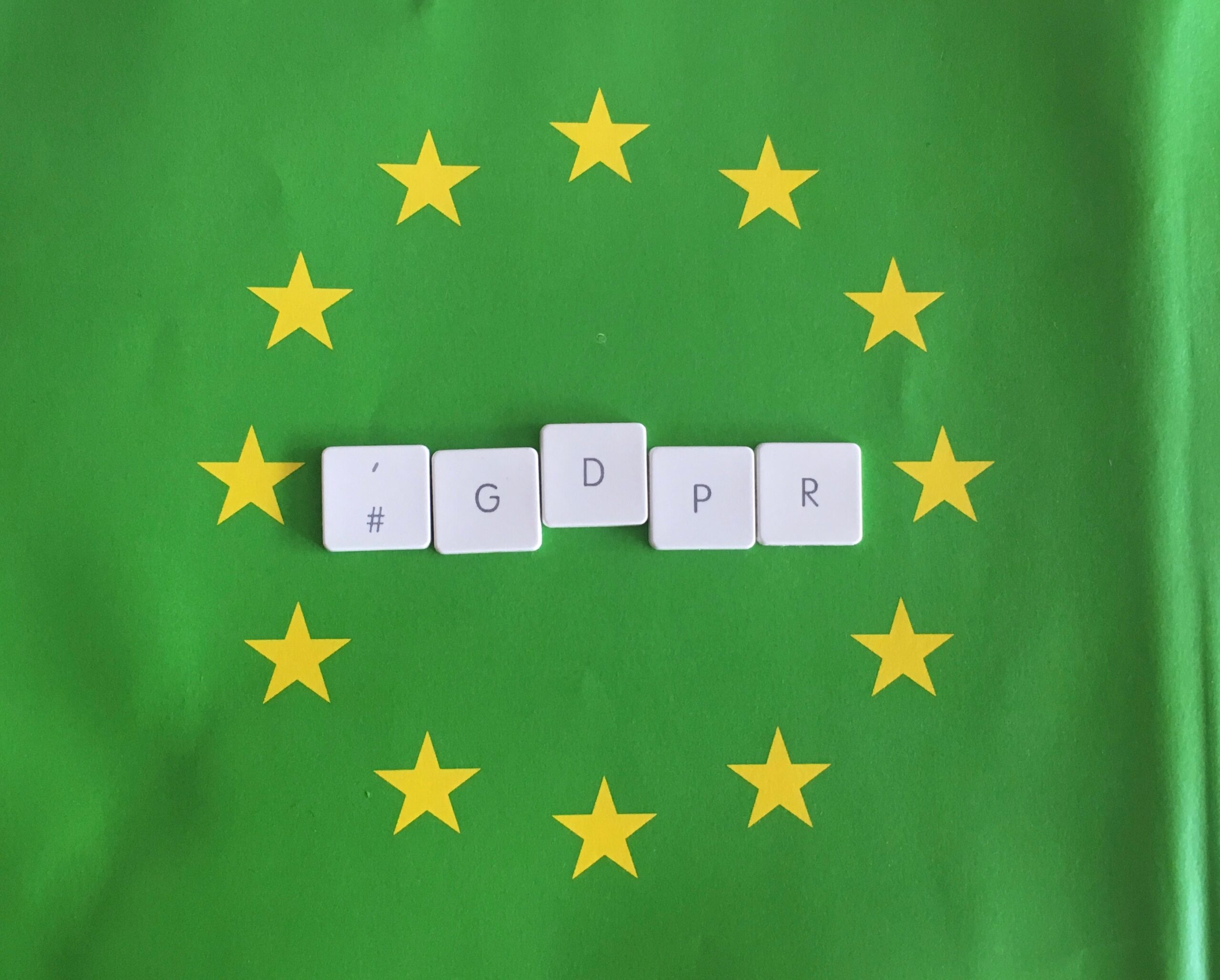 Green European Union flag with yellow stars and GDPR spelt out in keyboard letters