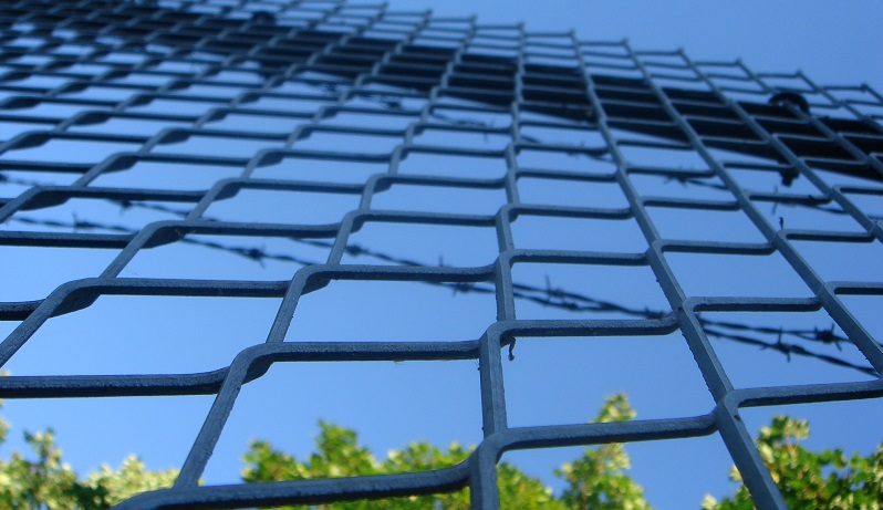 Image of barbed wire outside a prison (Image from Flickr: https://www.flickr.com/photos/dogbomb/641416098)