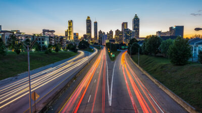 Timelapse photo of cars on a highway and a city in the background