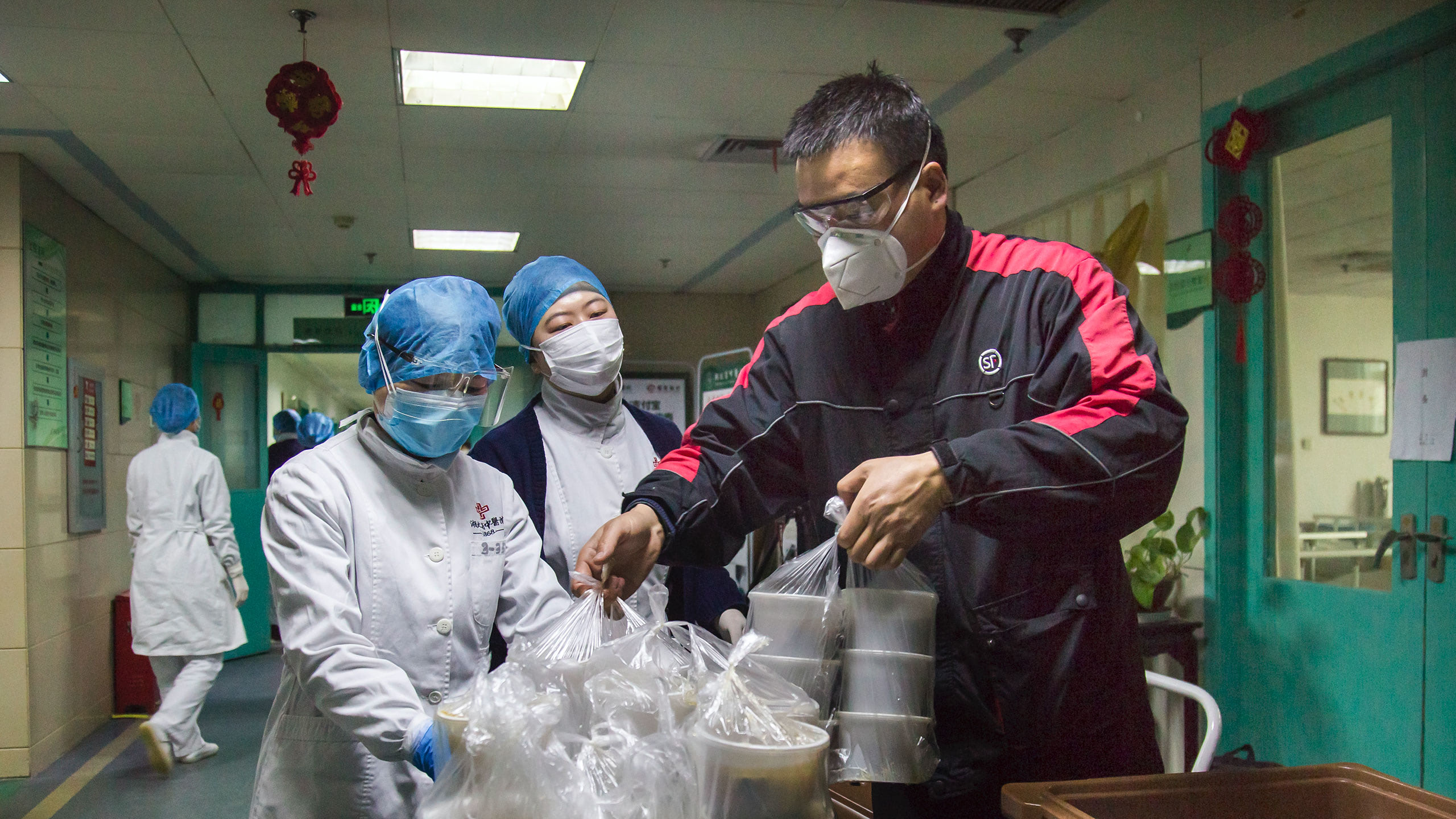 People in protective clothing packaging meals