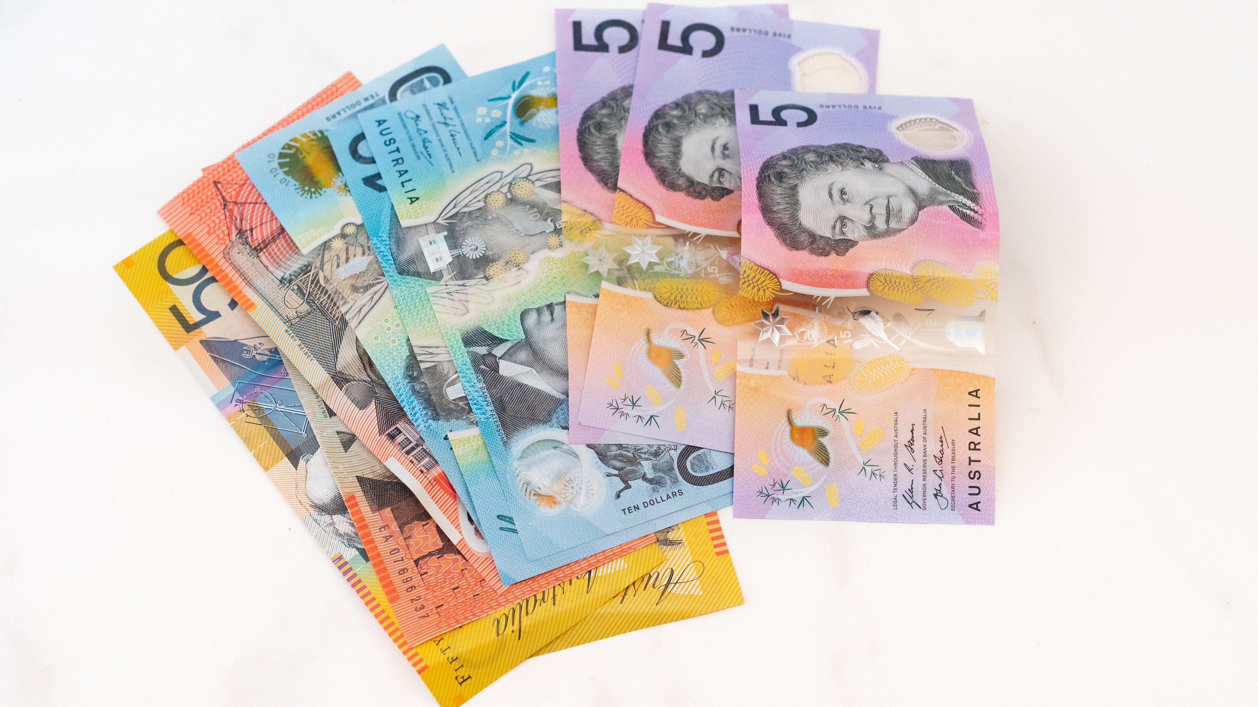 Assortment of Australian bank notes on a white table