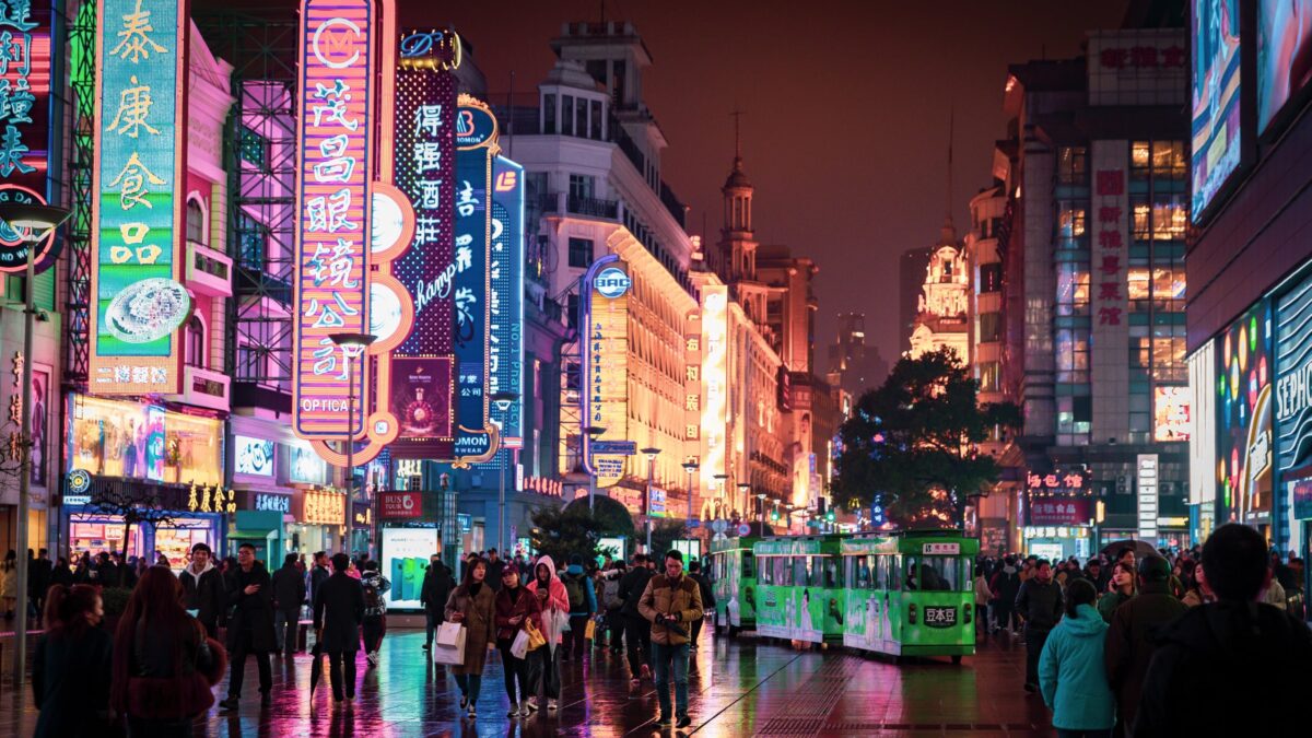 Chinese city street at night showing large neon signs